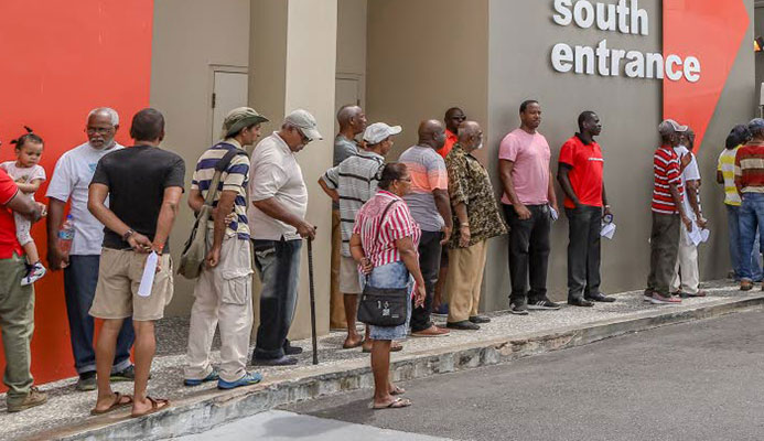 Members of the public wait in long lines to enter the Health Ministry's Men's Wellness Initiative Clinic at the Colposcopy Centre in the Mt Hope Women's Hospital yesterday.