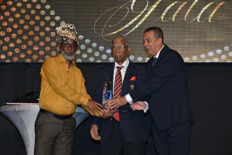 RESPECTED LEADER, ADMINISTRATOR AND MOTIVATOR: In one of his rare public appearances in his last years, former Olympic Committee president Alexander Chapman, centre, joined President Anthony Carmona, right, in presenting the Alexander B Chapman Award to football coach Anthony “Dada”   Photo: ISHMAEL SALANDY