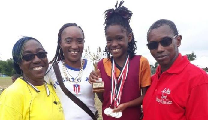 La Brea RC athlete, Chelcia Joseph (second from right), shows off her Girls U-11 Victrix trohpy and four gold medals (long jump, 100m, 200 and 4x100m relay) at her zone's Primary Schools' Track and Field Championships at Sobo Recreation Ground on February 14. She is joined by (left to right) La Brea RC teacher Sharnol Smith-Small, mother Mitchelle Joseph and principal Leon Charles. - Chequana Wheeler