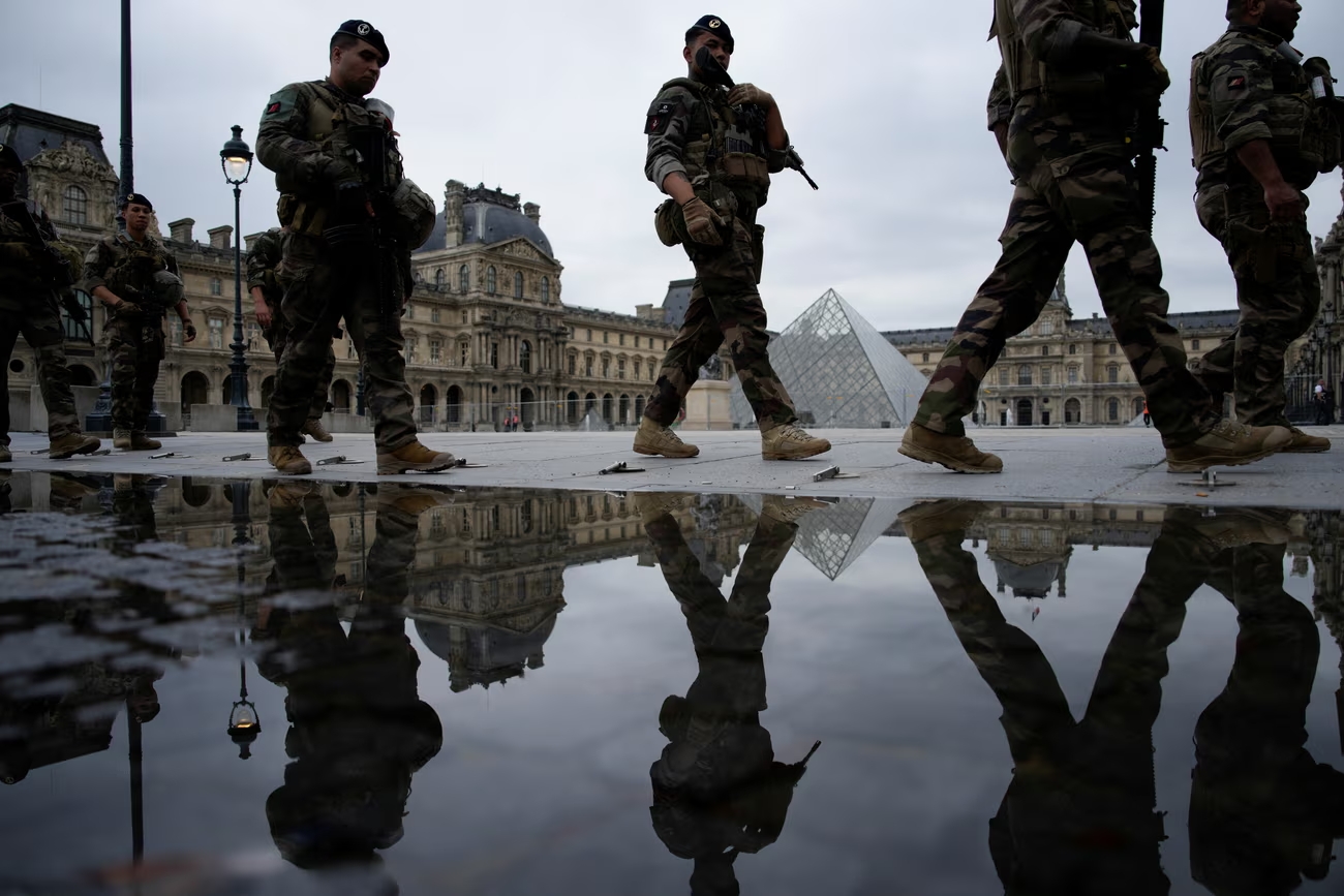 A security patrol in front of the Louvre before the opening ceremony. Fears of major disruption have been unfounded. Photograph: John Locher/Reuters (Image obtainaed at theguardian.com)