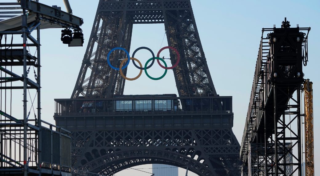 The Olympic rings are seen on the Eiffel Tower Friday, June 7, 2024 in Paris. The Paris Olympics organizers mounted the rings on the Eiffel Tower on Friday as the French capital marks 50 days until the start of the Summer Games. The 95-foot-long and 43-foot-high structure of five rings, made entirely of recycled French steel, will be displayed on the south side of the 135-year-old historic landmark in central Paris, overlooking the Seine River. (Michel Euler/AP) (Image obtained at sportsnet.ca)