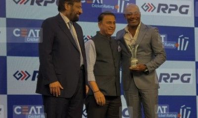 Brian Lara, right, poses with his CEAT Lifetime Achievement Award which was presented to him by Indian legend, Sunil Gavaskar (centre). (Image obtained at guardian.co.tt)